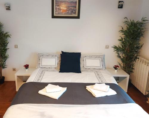 a bedroom with a bed with two towels on it at Red Clay Apartments City Club in Belgrade