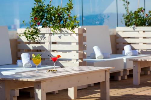 a wooden table with two drinks on a patio at Aparthotel Los Dragos del Sur in Puerto de Santiago