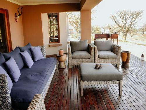 a living room with a blue couch and chairs at Cwebile Guesthouse in Winterton