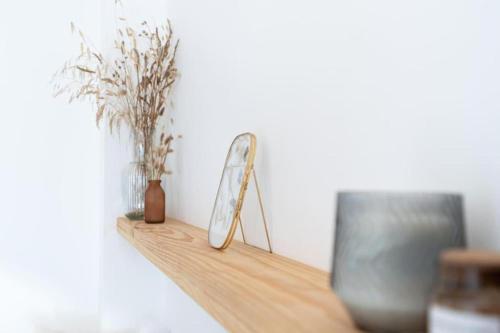 a shelf with a mirror and some plants on it at Appartement rénové, charme naturel et authenticité au cœur du village in Sorède