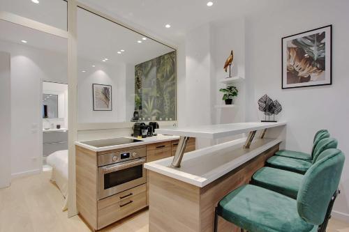 La cuisine est équipée d'un comptoir, d'un évier et d'un miroir. dans l'établissement Elegant 1BR - 4P - Eiffel Tower - Trocadero, à Paris