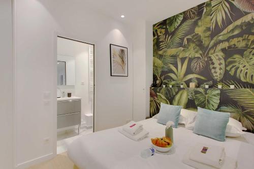 - une chambre avec un lit blanc et un papier peint tropical dans l'établissement Elegant 1BR - 4P - Eiffel Tower - Trocadero, à Paris