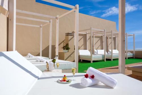 a white table topped with white chairs next to a pool at Aparthotel Los Dragos del Sur in Puerto de Santiago