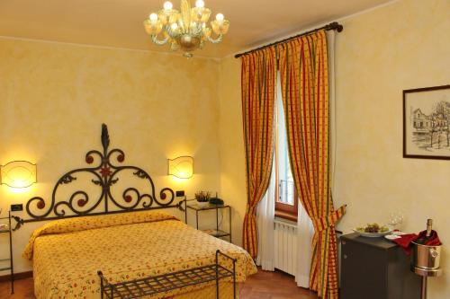 a bedroom with a bed and a chandelier at La Valletta Relais in Bergamo