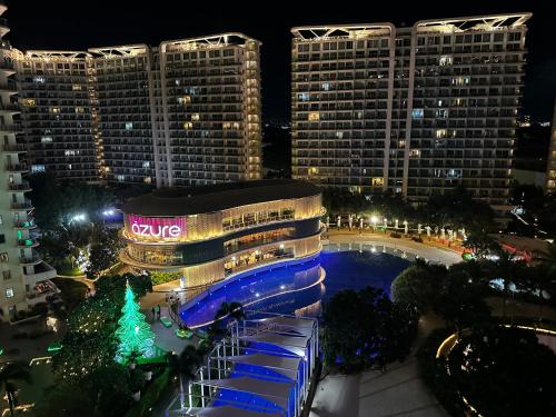 a view of a building with a pool at night at Azure Urban Resort South Paranaque Beach View Unit- Newly Renovated - Near Airport Near SM Bicutan in Manila