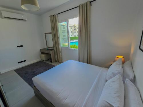 a bedroom with a white bed and a window at Palma Hotel in Port Said
