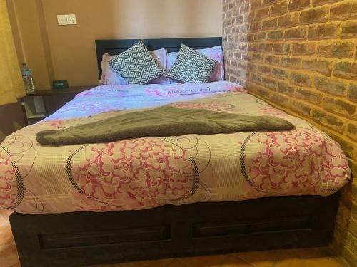 a bedroom with a bed with a brick wall at Bhaktapur Boutique Hotel and Restaurant in Bhaktapur