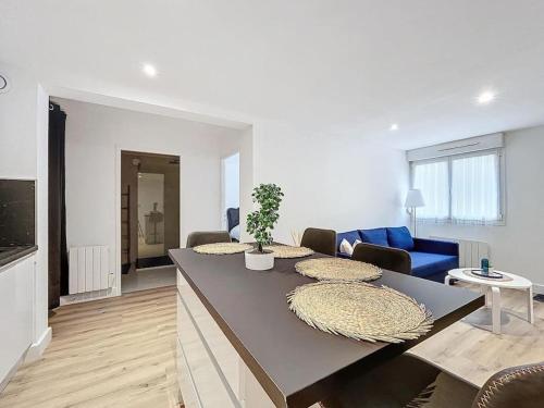 un salon avec une table et un canapé bleu dans l'établissement Escapade confortable et chic parking et vélo-box, à Montbéliard