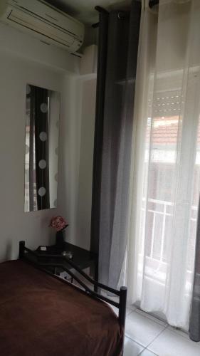 ein Schlafzimmer mit einem Bett und einem Fenster mit Vorhängen in der Unterkunft Mini home in Thessaloniki