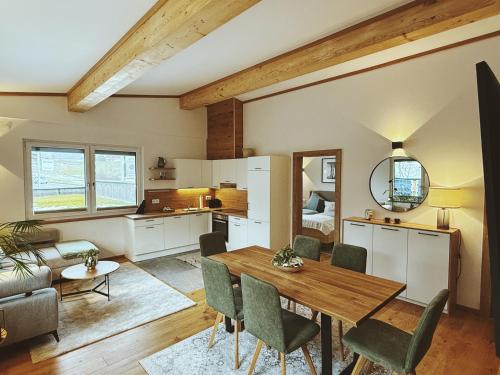 eine Küche und ein Wohnzimmer mit einem Holztisch und Stühlen in der Unterkunft Panoramablick Apartment Bad Aussee in Bad Aussee