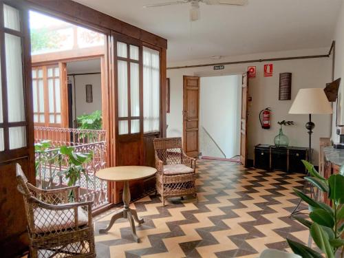 a room with a table and chairs and a balcony at Hotel Rural La Vida de Antes in Consuegra