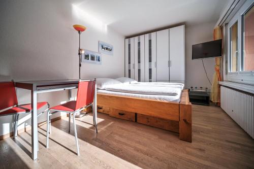 - une chambre avec un lit, un bureau, une table et des chaises dans l'établissement Paradies 606, à Arosa