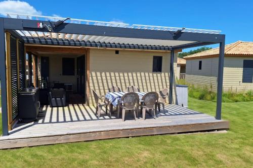 un patio avec une table et des chaises sur une terrasse dans l'établissement Le Chalet Treoty - Welkeys, à Saubrigues
