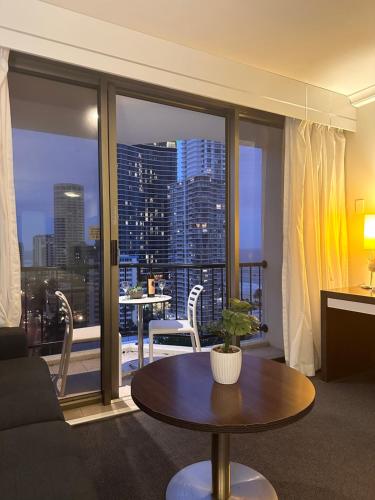 Una sala de estar con una mesa y una gran ventana. en Studio Mantra on View, en Gold Coast