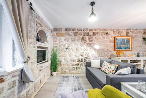 a living room with a stone wall at Villa Dovecote with Private Sauna, Jacuzzi & Gym in Ston