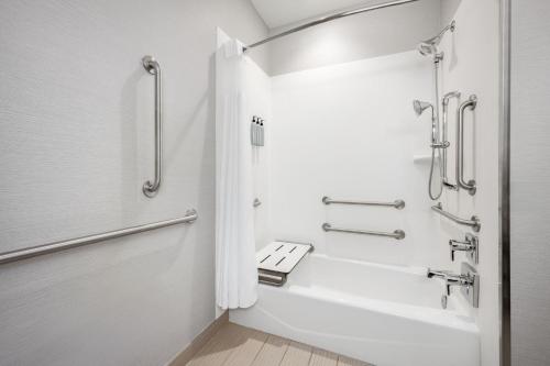 a white bathroom with a shower and a toilet at Courtyard by Marriott Auburn in Auburn