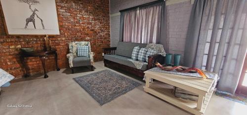 a living room with a couch and a chair at Valley Bushveld Country Lodge in Addo