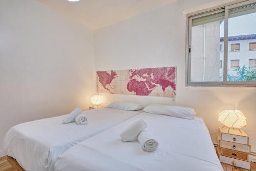 two white beds in a bedroom with a window at Casa De Esme ll in Haro