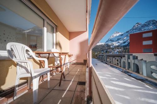 a balcony with chairs and a table and mountains at Paradies 212 in Arosa