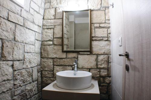 bagno con lavandino e parete in pietra di Petrina Villa A a Kastrí