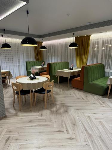 a waiting room with tables and green chairs at Guest House Zatyshnyi Dvir in Bukovel