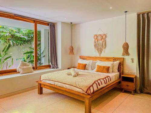 a bedroom with a bed and a large window at Marlaca Villas Lombok in Kuta Lombok
