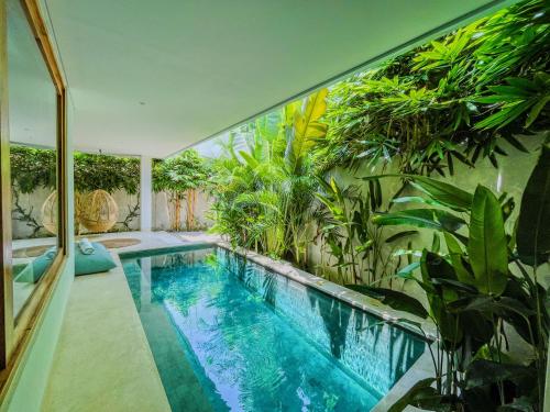 an indoor pool in a house with plants at Marlaca Villas Lombok in Kuta Lombok