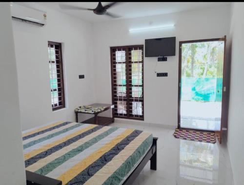 a bedroom with a bed and a flat screen tv at Heaven Residency in Munroe Island