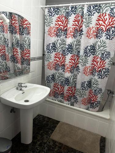 a bathroom with a sink and a shower curtain at Casa La Alpispa in Frontera