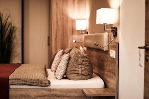 um quarto de hotel com uma cama com almofadas em Pension Carlbauer em Kelheim