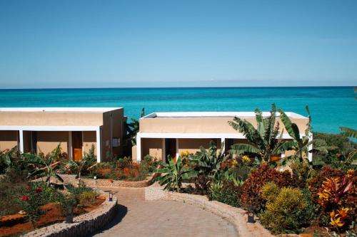a house with a garden in front of the ocean at Oasis Blu Beach Resort-Adults Only in Nungwi
