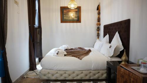 a bedroom with a bed with white sheets and pillows at RIAD KALE POLIS in Marrakech
