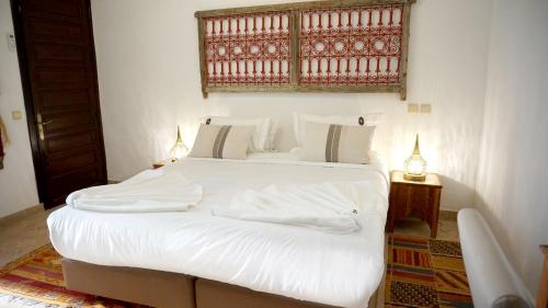 a white bed with white sheets and pillows on it at RIAD KALE POLIS in Marrakech