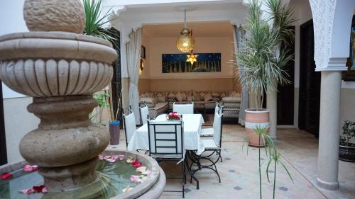 a restaurant with a fountain and a table and chairs at RIAD KALE POLIS in Marrakech