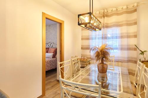 a dining room with a glass table and a mirror at Casa Arroyo Colmenar in Villanueva del Arzobispo