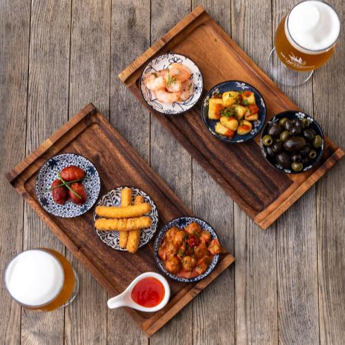 a table with plates of food on a wooden tray at The Lansdowne, Eastbourne in Eastbourne