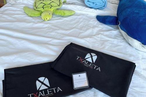 a bed with a zakaria bag and a stuffed turtle at Txaleta de Camiguin desde 2024 in Mambajao