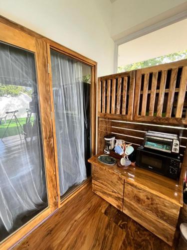 a room with a wooden desk with a microwave and a window at Txaleta de Camiguin desde 2024 in Mambajao