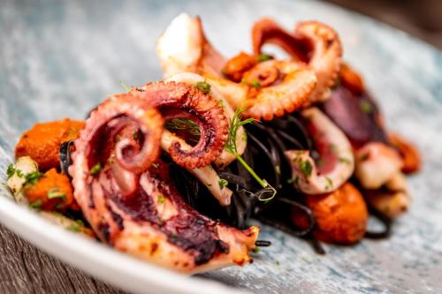 a plate of food with octopus on a table at The Lansdowne, Eastbourne in Eastbourne