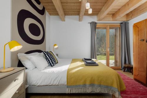 a bedroom with a bed and a large window at Le Refuge Au Pied d'Hauto in Montriond