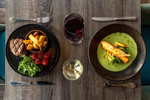 a table with two plates of food and a glass of wine at The Lansdowne, Eastbourne in Eastbourne