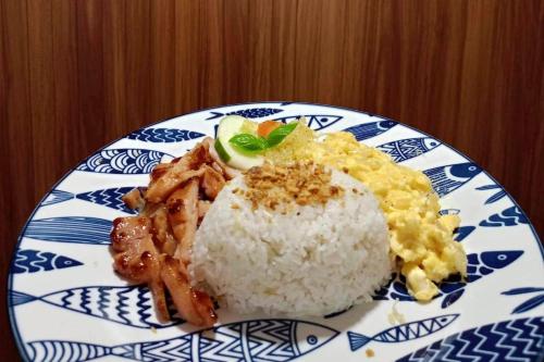 a blue and white plate of food with rice at Txaleta de Camiguin desde 2024 in Mambajao