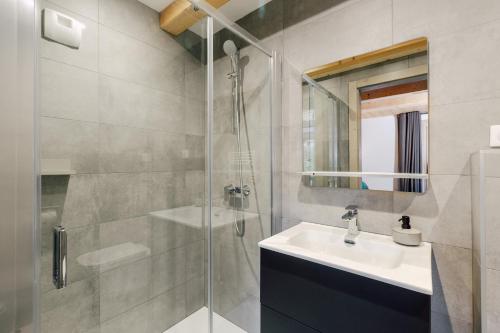 a bathroom with a sink and a glass shower at Le Refuge Au Pied d'Hauto in Montriond