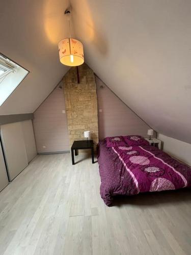 - une chambre mansardée avec un lit violet dans l'établissement Maison de campagne 6 personnes, à Colombiers-sur-Seulles