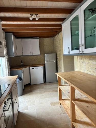 une cuisine avec des armoires blanches et un comptoir dans l'établissement Maison de campagne 6 personnes, à Colombiers-sur-Seulles