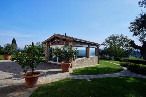 a small greenhouse in a garden with potted plants at Villa La Fornace in Tavarnelle in Val di Pesa