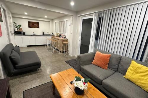 a living room with a couch and a table at Cozy 1 Bed 1 Bath Studio Kingsland - Morningside in Auckland