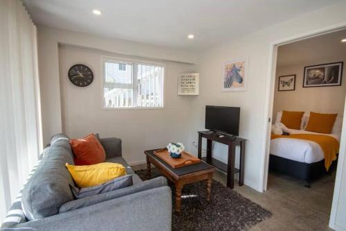 a living room with a couch and a bed at Cozy 1 Bed 1 Bath Studio Kingsland - Morningside in Auckland