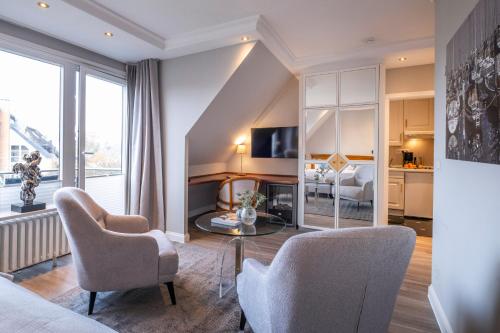 a living room with a couch and two chairs and a table at Büngers Apartment-Hotel mit Sommerstrandkorb & Gartensauna in Strande