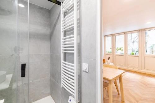 La salle de bains est pourvue d'une douche et d'une table. dans l'établissement Bel appartement parisien, à Paris